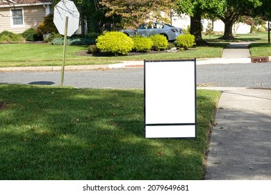 Blank White Lawn Sign With Two Panels On A Green Grass Lawn Near A Sidewalk And Street On A Sunny Day