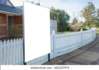 Blank White Mockup Template Of A Real Estate Advertisement Billboard/sign/board At Front Of A Property/residential House With White Wood Picket Fence In An Australian Suburb. 