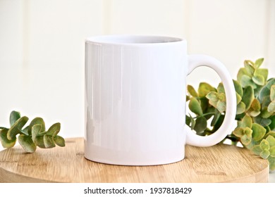 Blank white mug mockup photo with eucalyptus ,11 oz mug on wood table
