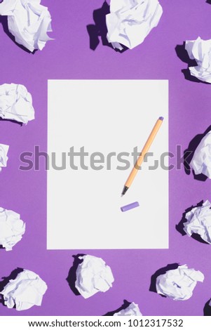 Blank white page and fineliner laying on vivid violet background, creased paper around it.