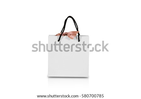 Blank white paper gift bag with a bow mock up. Isolated on white background. Empty plastic package mockup stand on table isolated. Consumer pack ready for logo design or identity presentation.