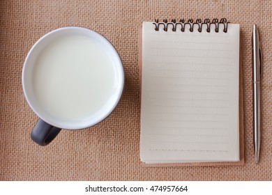 Blank White Paper With Glass Of Milk From Above On Table. Copy Space, Top View.