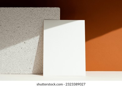 Blank white paper mockup on brown background. Sun and shade, shadows on background.