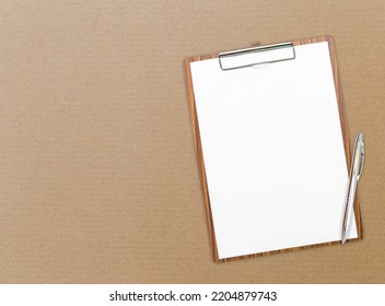 Blank White Paper On Wooden Clipboard With Pen On Brown Card Board Paper Box Background, Business And Education Concept