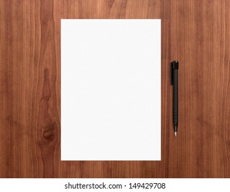 Blank White Paper With Pen On A Wooden Desk. High Quality Graphic Collage.