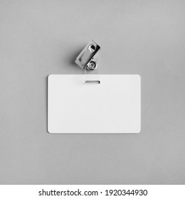 Blank white plastic badge on gray paper background. Responsive design template. Mock-up for your design. Flat lay.