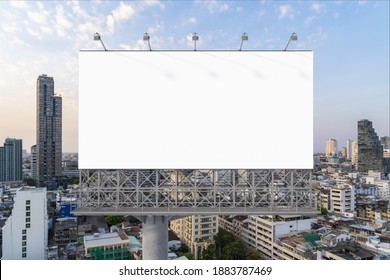 Blank white road billboard with Bangkok cityscape background at sunset. Street advertising poster, mock up, 3D rendering. Front view. The concept of marketing communication to promote or sell idea. - Shutterstock ID 1883787469
