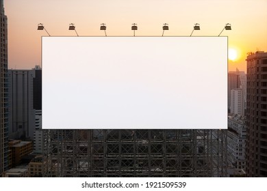 Blank white road billboard with Bangkok cityscape background at sunset. Street advertising poster, mock up, 3D rendering. Front view. The concept of marketing communication to promote or sell idea. - Shutterstock ID 1921509539