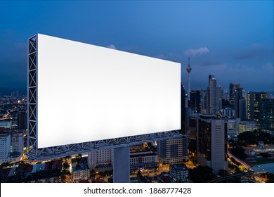 Blank white road billboard with KL cityscape background at night time. Street advertising poster, mock up, 3D rendering. Side view. The concept of marketing communication to promote or sell idea. - Shutterstock ID 1868777428