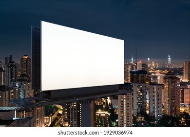 Blank white road billboard with KL cityscape background at night time. Street advertising poster, mock up, 3D rendering. Side view. The concept of marketing communication to promote or sell idea. - Shutterstock ID 1929036974