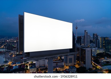 Blank white road billboard with KL cityscape background at night time. Street advertising poster, mock up, 3D rendering. Side view. The concept of marketing communication to promote or sell idea. - Shutterstock ID 1936328911