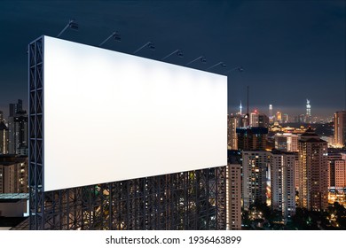 Blank White Road Billboard With KL Cityscape Background At Night Time. Street Advertising Poster, Mock Up, 3D Rendering. Side View. The Concept Of Marketing Communication To Promote Or Sell Idea.