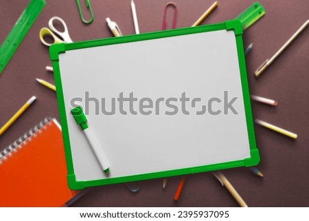 Blank white school board with space for text. WhiteBoard Easel for Kids Drawing Memo to Do List on wood background with stationery. Template with copyspace for advert, blog.