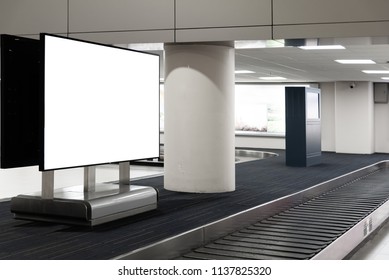 Blank White Screen Advertising Sign At Baggage Claim Conveyor In The Airport.