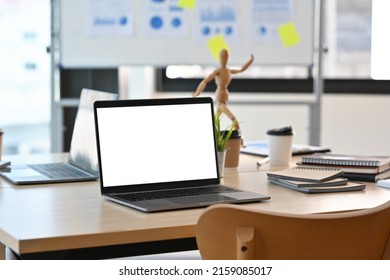 A Blank White Screen Laptop Computer Setting On The Wooden Desk With The Modern Interior Office Decoration. Business And Financial Concepts.