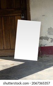 A blank white sign board leaning against a wall, Real shadow, and the background blur