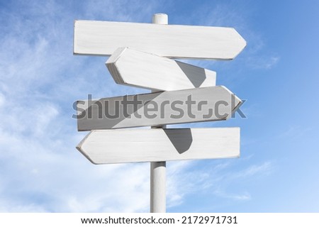 Blank white signpost with blue sky with white clouds background. Choose the correct way concept. Mock up, template