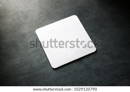 Blank white square beer coaster mockup lying on the textured background. Squared clear design mock up top view. Quadrate cup rug display, isolated.