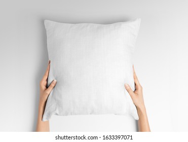 Blank white square pillow mockup holding with two hands by woman