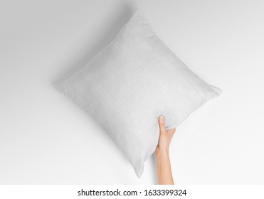 Blank white square pillow mockup holding with one hand by woman