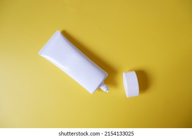 A Blank White Squeeze Bottle Plastic Tube On Yellow Background. Packaging Of Cream, Lotion, Gel, Facial Foam Or Skincare. Cosmetic Beauty Product Branding Mock-up. Copy Space