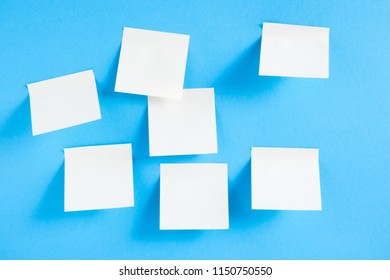 Blank White Sticky Notes On Blue Background, Concept Of Business Work. White Memo Stickers On Blue Wall. Mock-up