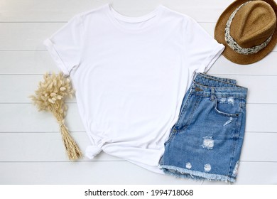 Blank white t shirt. Flat lay, top view travel fashion boho style look with woman clothes and accessories