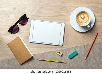 Blank white tablet with copy space for writing a message lying on office desk  with notebook as flat lay from bird's eye view