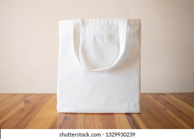 Blank White Tote Bag Canvas Fabric With Handle On Wooden Table. Eco Or Reusable Shopping Bag. No Plastic Bag And Ecology Concept.