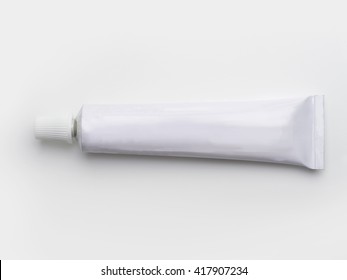  A blank white tube commonly used for pharmaceutical use or chemical products such as adhesives. Isolated on natural white background.