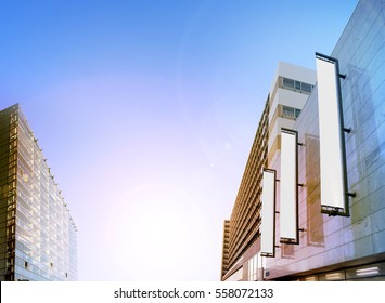 Blank White Vertical Banners On Building Facade, Design Mockup. Store Flags Mock Up On The Street. Outdoor Flagpole Template On The Side Of The Hotel Exterior. Three Signages Hanging The Wall.