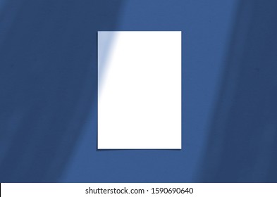 Blank white vertical paper sheet 5x7 inches with shadow overlay. Modern and stylish greeting card or wedding invitation mock up. Color of the year 2020 classic blue.