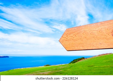 Blank wooden arrow over clear blue sky in countryside with copy space, just add your text here