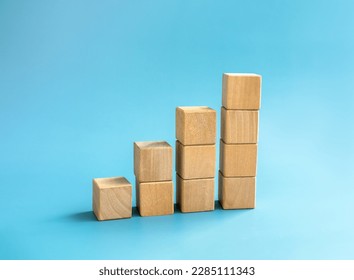 Blank wooden cube blocks bar graph chart steps, isolated on blue background, investment, income, trends, inflation, business growth, economic improvement concepts. Four step eco style wood graph. - Powered by Shutterstock