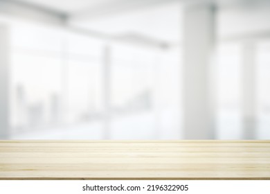 Blank wooden desktop with empty space on modern office interior with large window background, closeup, mock up - Shutterstock ID 2196322905