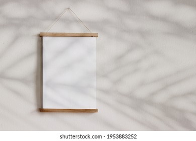 Blank Wooden Picture Frame Hanging On Beige Wall. Empty Poster Mockup For Art Display In Sunlight. Minimal Interior Design.Palm Leaves Shadow Overlay. Summer Design. Copy Space. No People. 