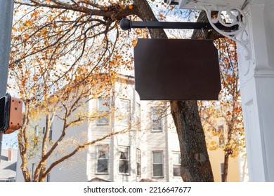 A Blank Wooden Sign Hanging Outside A House With Autumn Trees In The Background