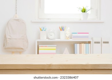 Blank wooden table top on blurred schoolchild room interior background