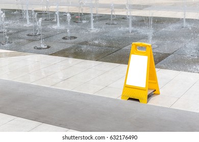 Blank Yellow Hazard Sign Alerts For A Wet Floor In Fountain Decoration Area.