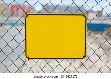 Blank Yellow Sign On Construction Site Fence - Warning Sign Mockup