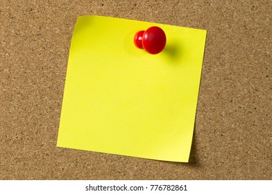 Blank Yellow Sticky Note Pad Pinned To Corkboard Using A Red Thumb Tack Pin