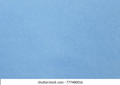 The Blanket Of Furry Blue Fleece Fabric. A Background Texture Of Light Blue Soft Plush Fleece Material