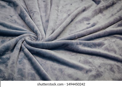 The Blanket Of Furry Fleece Fabric. A Background Soft Plush Fleece Material With A Lot Of Relief Folds