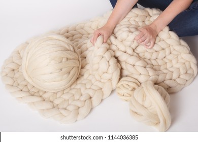 Blanket Made Of Merino Wool And Yarn Balls On White Background. Women's Hands Holding A Ball.