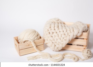 Blanket Made Of Thick Merino Yarn And Wool Balls In Wooden Boxes On White Background.