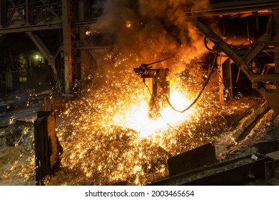 Blast furnace, cast iron production. Metal poured out of the metallurgical furnace, many bright sparks and smoke. - Shutterstock ID 2003465654