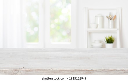 geblähter Holztisch auf unscharfem Küchenfensterhintergrund