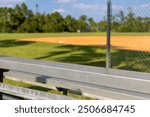 Bleachers on the sideline of a baseball and softball recreation field in a park where parents sit and watch.