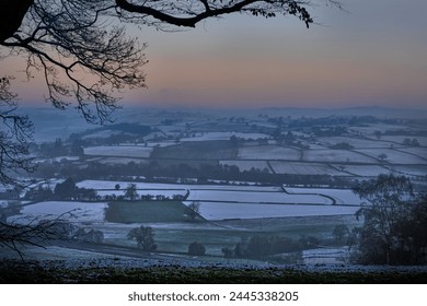 Bleak midwinter in mid Wales with bare tree and snowy fields . Dawn sunrise. - Powered by Shutterstock