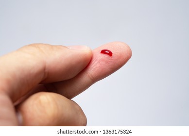 Bleeding blood from the cut finger wound. Injured finger with bleeding open cut wound. Closeup of finger human hand is cut hurt bleeding with bright red blood. 